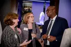Dean Kerwin Charles talking with colleagues at an event
