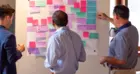 Three people working with an idea board