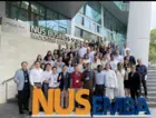 Group of students in front of a sign that says NUS EMBA