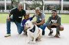 Two adults and two children posing with a bulldog