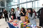 A group of students choosing books from a display table
