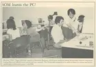 A black-and-white newspaper photo of people working in a computer lab