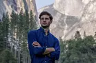 photo of someone with arms crossed standing in a mountain range