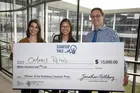 three people hold a large check made out to OnTrack Rehab