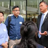 group of students chatting with Raymond Chang ’96