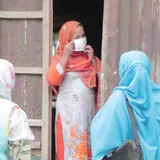 A woman putting on a mask in Bangladesh