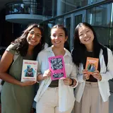 Three women holding books by Hispanic authors