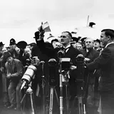 Prime Minister Neville Chamberlain waves to the crowd at Heston Airport