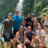 Group of friends outside in front of a waterfall