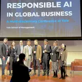 A group of student organizers posing onstage at a conference