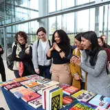 A group of students choosing books from a display table