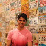 A person standing in front of a wall of license plates
