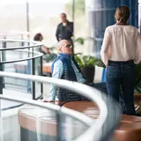 Several people talking in a mezzanine in Evans Hall