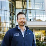 A person wearing a Yale SOM sweatshirt standing outside Evans Hall