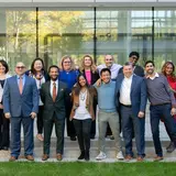 group of 13 people in business casual attire standing outdoors in Evans Hall courtyard